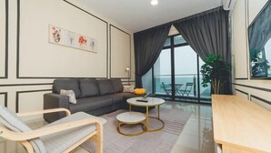 A modern living room with a sofa, a round coffee table, and a dining table. - Marina Residence 3BR Shores Haven nr Midvalley CIQ (Plentong)