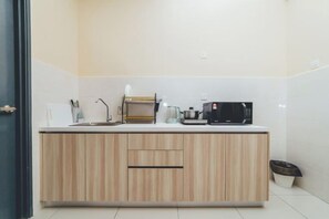 A modern kitchen with a wooden countertop, a coffee maker, a microwave, and a sink. - Marina Residence 3BR Shores Haven nr Midvalley CIQ (Plentong)