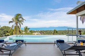 A poolside area with lounge chairs and a view of the ocean. - L'Esterel Villa - A Tropical Oasis at Maenam Hills (Koh Samui)