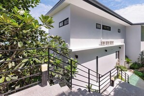 Un edificio moderno de dos pisos con una escalera que conduce al nivel superior.