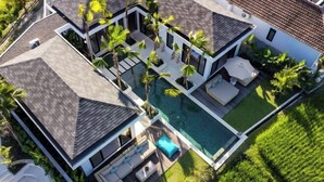 A modern house with a swimming pool, multiple rooms, and a well-maintained garden.