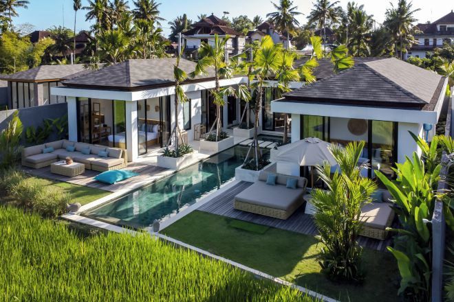Une maison moderne dotée d’une piscine, d’un espace salon extérieur et d’une végétation luxuriante.