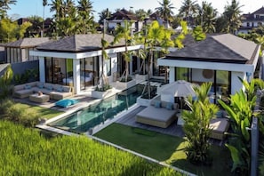 A modern resort with a swimming pool, lounge areas, and tropical landscaping. - Villa Juke by BaliSuperHost (Bali)