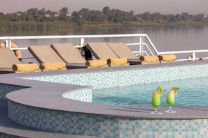 A pool with lounge chairs and a glass of drink on the edge. - Jaz Celebrity Nile Cruise - Every Saturday from Luxor for 07 & 04 Nights (At Tod)
