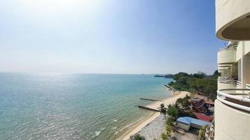 A coastal view from a balcony overlooking a beach and the sea.