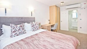 A bedroom with a bed, bedside lamps, a desk, and a wardrobe. - Eldon Chambers Pod 7 by City Living London (London)