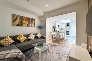 Een moderne woonkamer met een bank, salontafel en kunstwerk aan de muur.