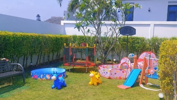 A fenced backyard with a trampoline, a slide, and a small pool. - Villa me & you2 (Cha-am)