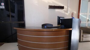Un mostrador de recepción con una computadora, una silla y un letrero que indica 'Solo para empleados'.
