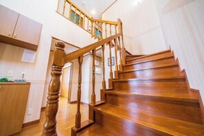 A wooden staircase with a handrail leading to an upper floor. - wing mihama (Chatan)