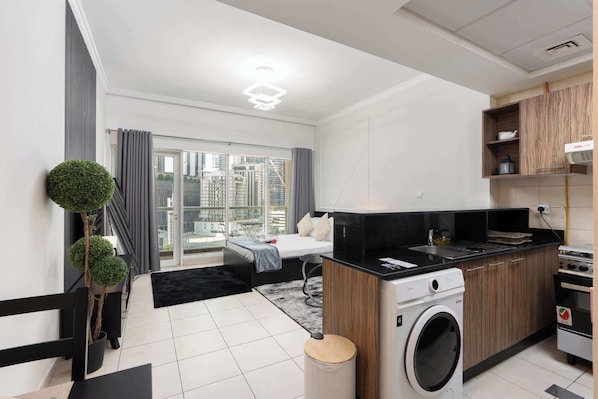 A modern apartment with a kitchen, a dining area, and a living space with a large window.