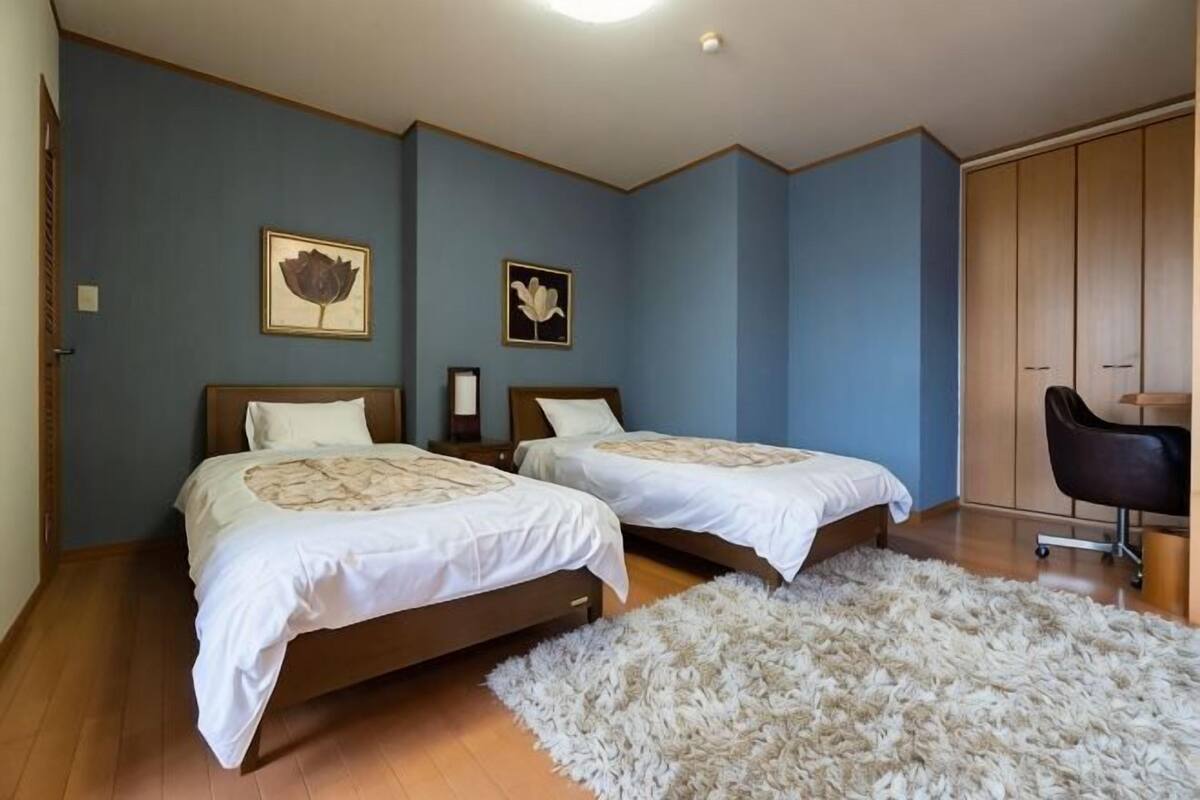 Une chambre avec deux lits, un bureau et une armoire.
