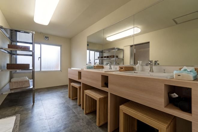 A modern bathroom with a large mirror, two sinks, and wooden storage compartments.