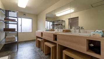 A modern bathroom with a large mirror, two sinks, and wooden storage compartments.