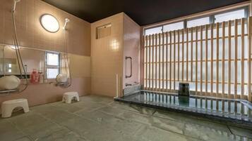 A bathroom with a glass shower enclosure, a toilet, and a sink.