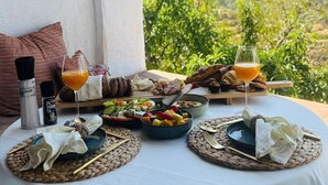 Une table dressée pour le petit-déjeuner, avec vue sur un paysage montagneux.