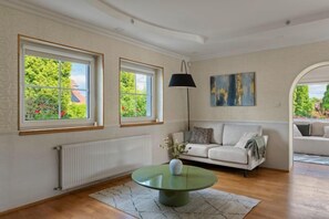 Une pièce avec un canapé, une table et un tableau au mur.