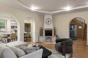 Un salon avec une cheminée, un coin repas et un escalier.