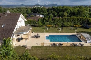 Il s’agit d’une propriété résidentielle dotée d’une piscine, d’un espace extérieur aménagé et offrant une vue sur un paysage montagneux.