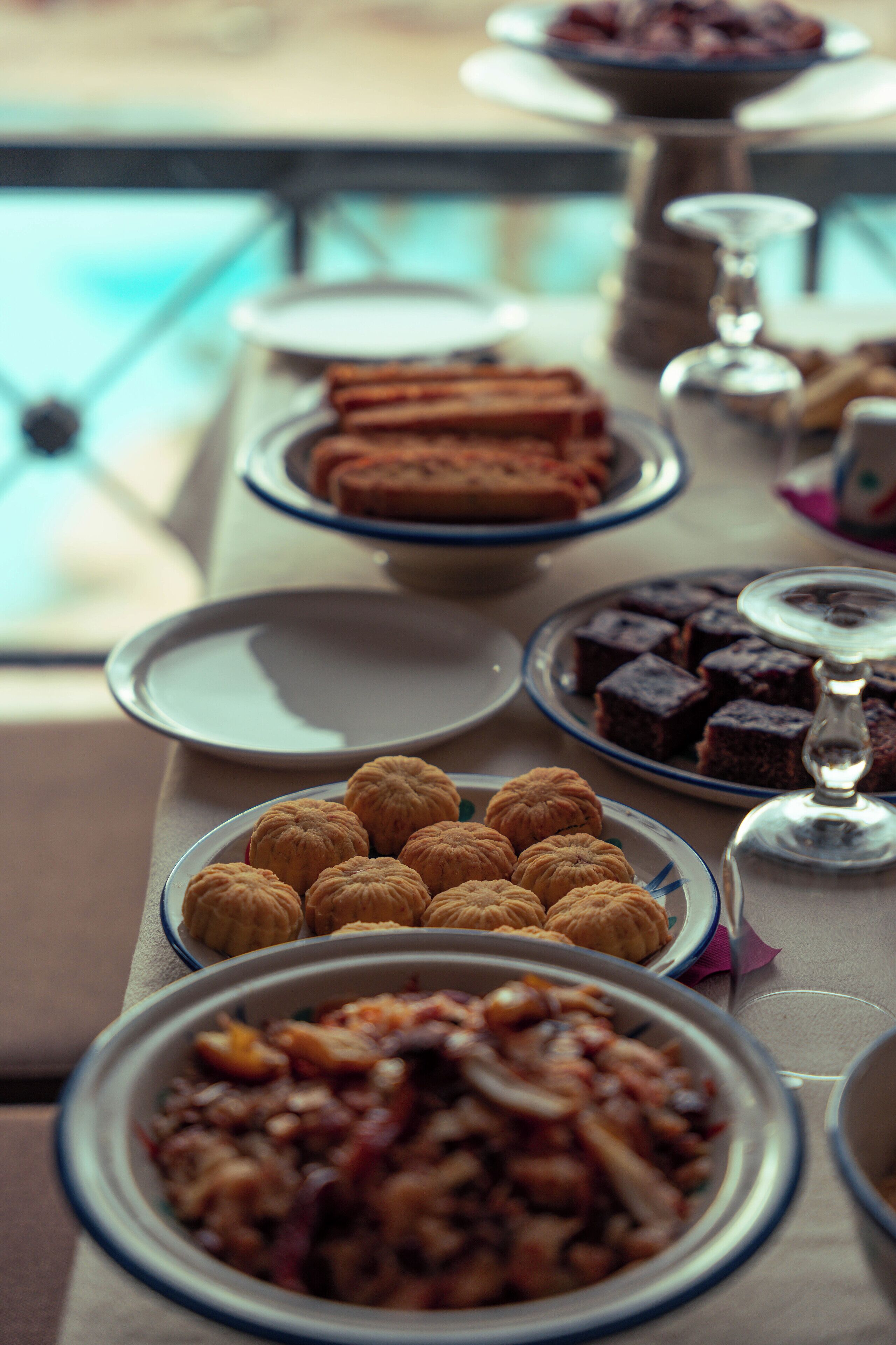 A table with various desserts and a glass of wine.