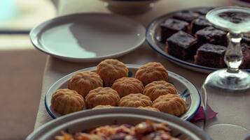 A table with various desserts and a glass of wine.