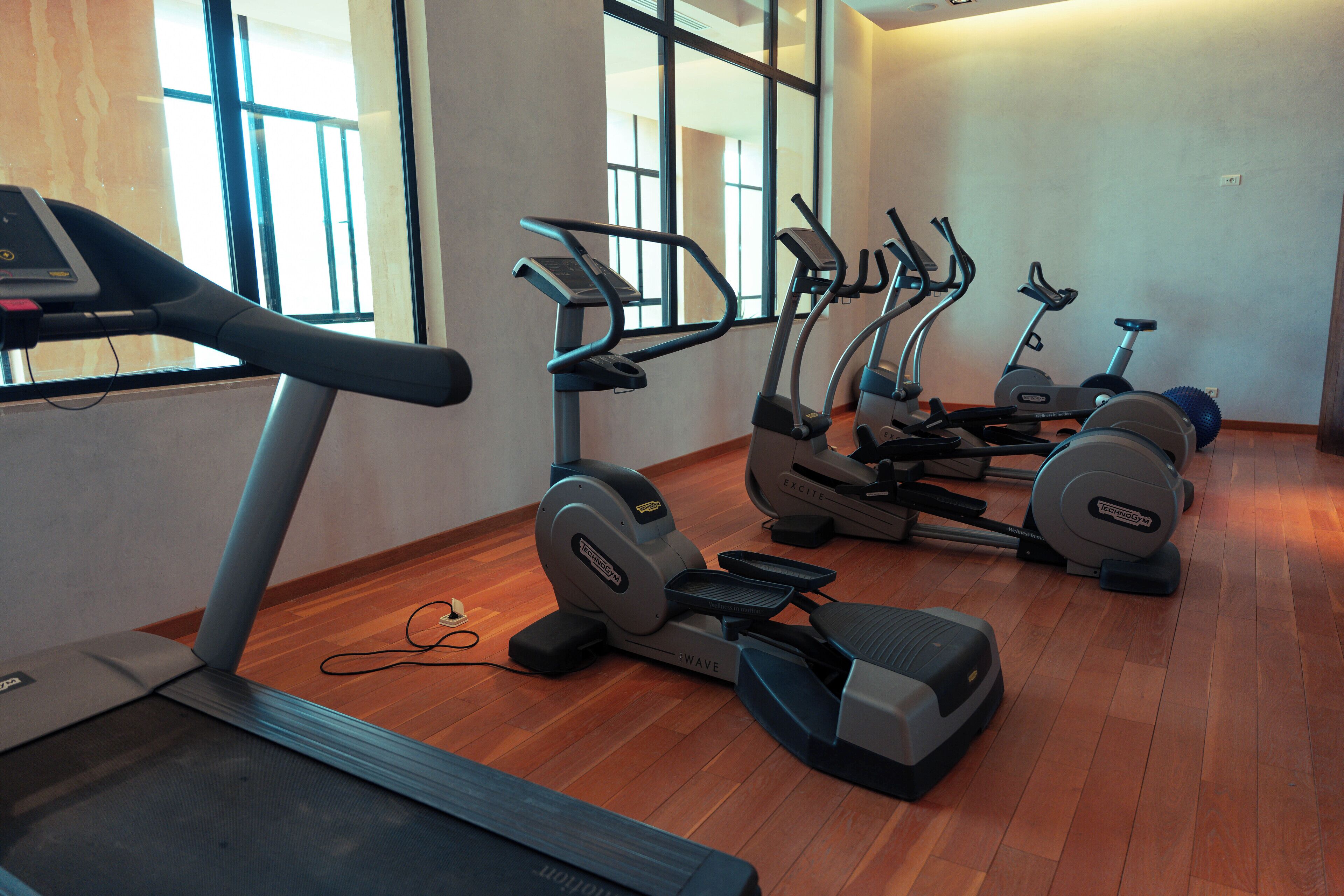 Un gimnasio con varias bicicletas estáticas y una cinta de correr.