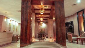 Un vestíbulo con mostrador de recepción, zona de estar y una fuente decorativa central.