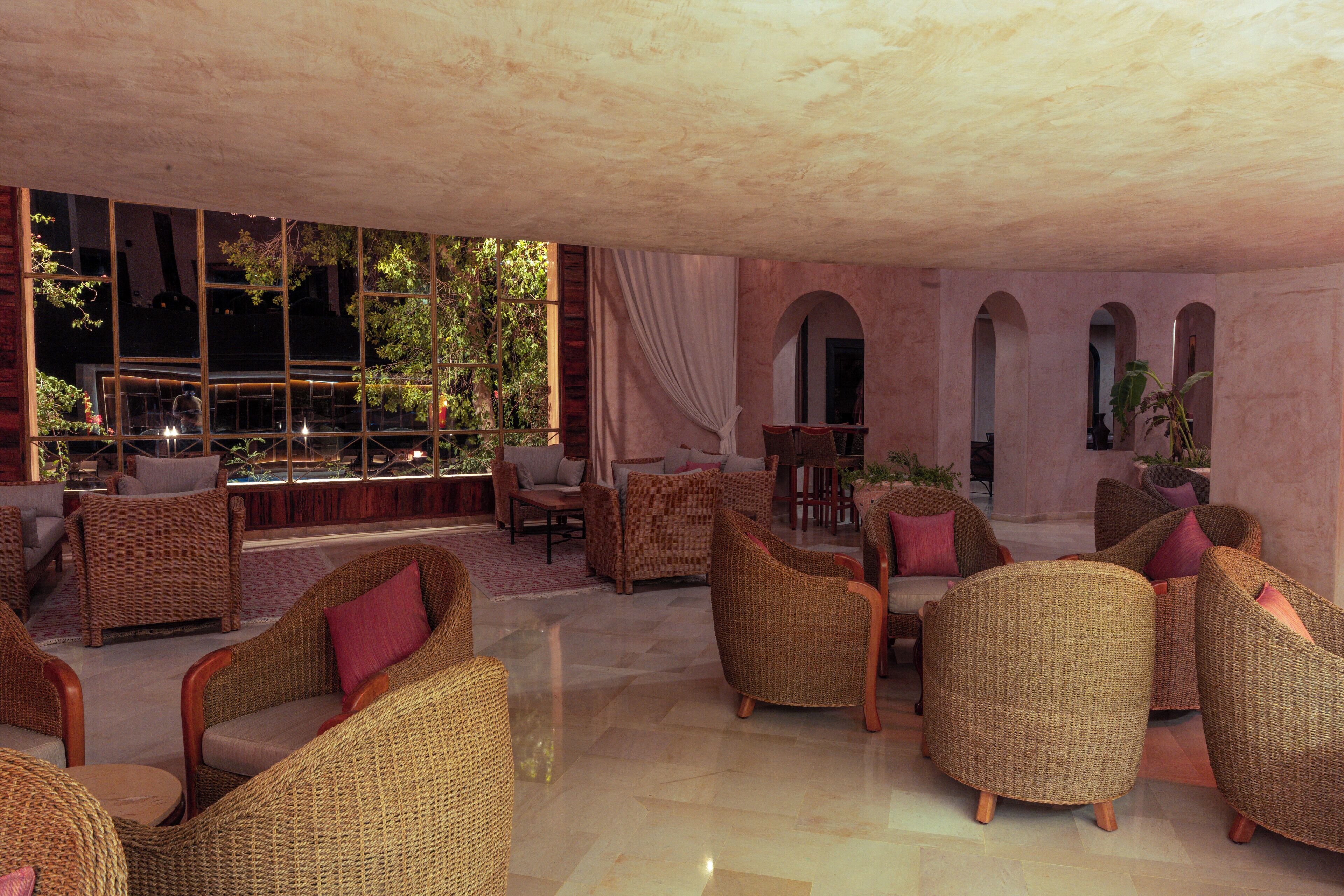 A spacious lounge area with wicker furniture and a view of the outdoors.
