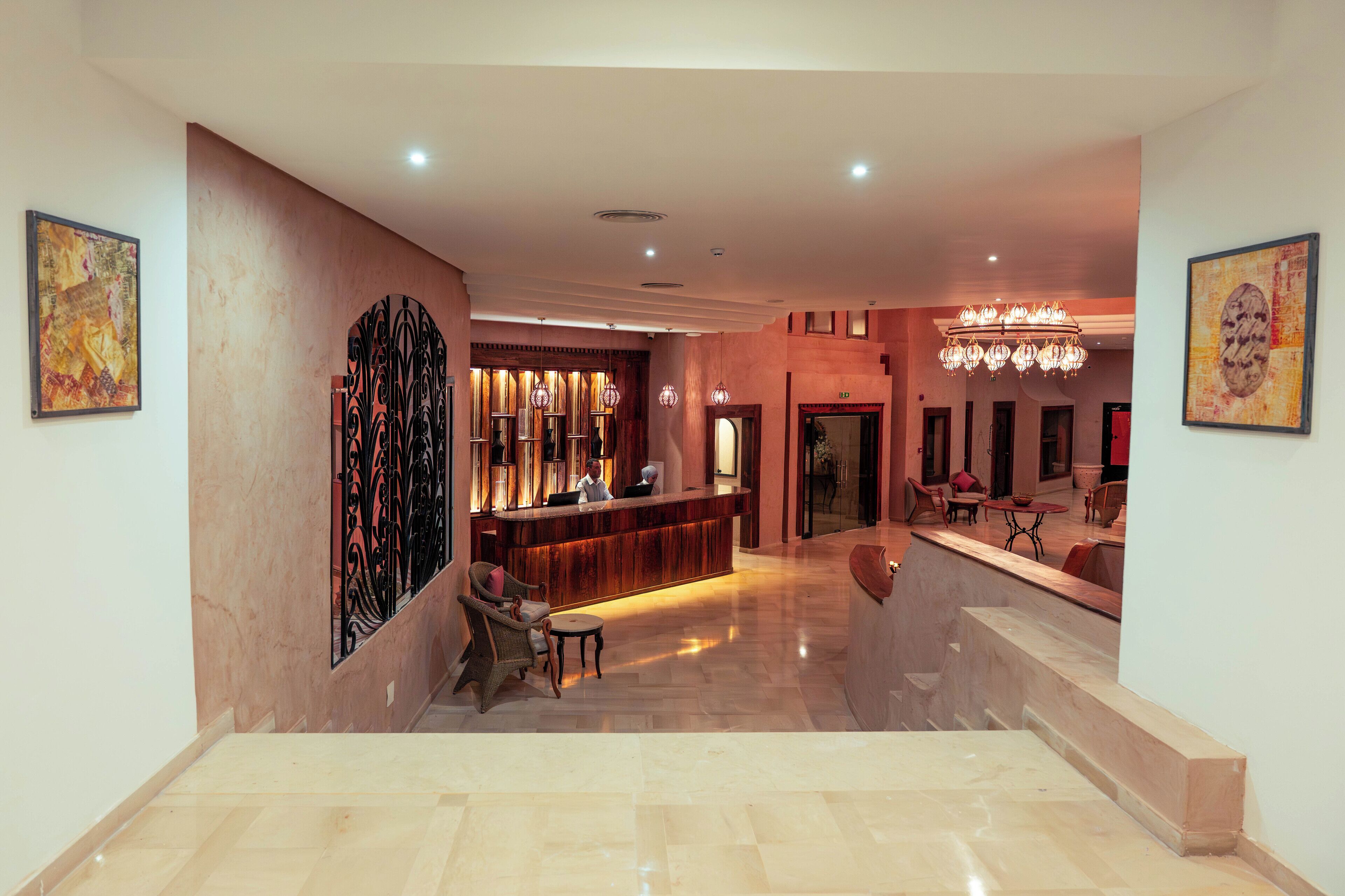 A spacious lobby with a reception desk, seating area, and a chandelier.