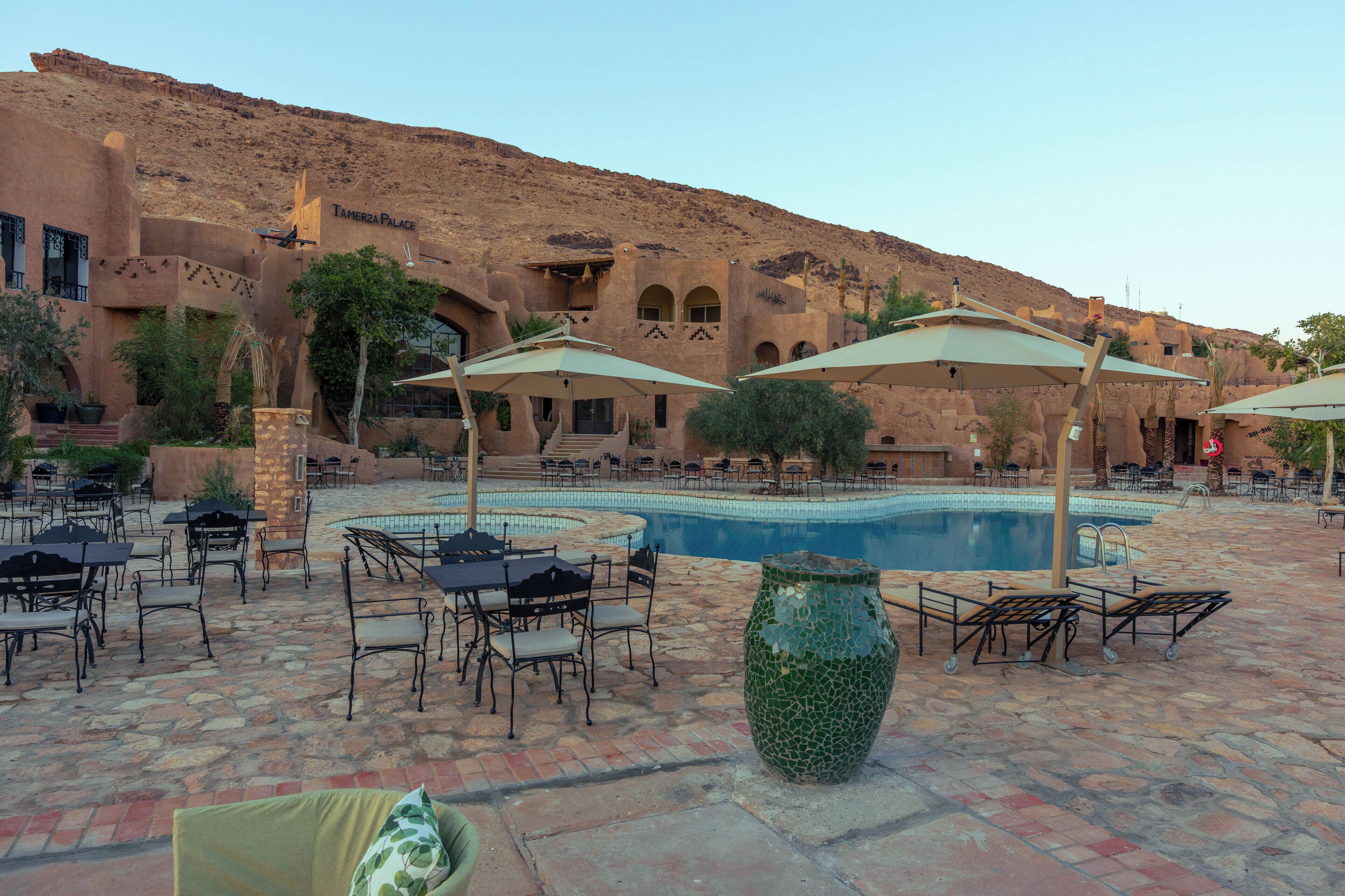 A poolside area with outdoor seating and a large decorative vase.
