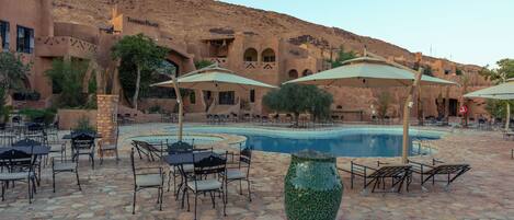 A poolside area with outdoor seating and a large decorative vase.