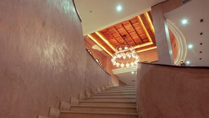 Una escalera con escalones de madera y un candelabro en la parte superior.
