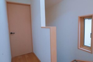 Une pièce avec une porte, une fenêtre et un coin doté d’un plancher en bois.