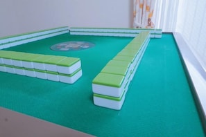A green mat with a white and green game board in the center.