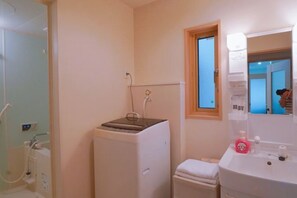 A bathroom with a shower, toilet, sink, and a window. - Toga hotel (Tokyo)