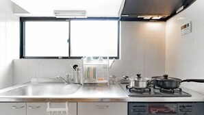 A modern kitchen with a large window, stainless steel appliances, and a dishwasher. - Younoyado (Osaka)