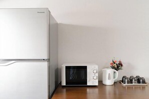 A kitchen with a refrigerator, microwave, kettle, and a tray of cups. - Younoyado (Osaka)