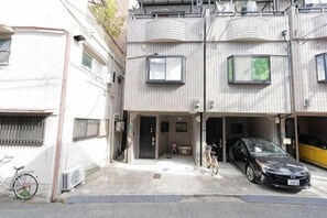 A residential building with a garage, bicycles, and a parked car.