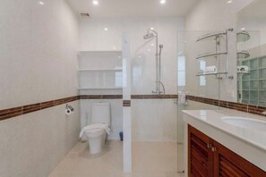 Un baño moderno con inodoro, ducha y tocador.