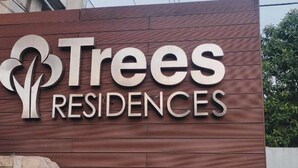 A sign for Trees Residences with a stylized tree logo and the name prominently displayed. - HapiBelles Staycation Trees Residence Tower 8 (Quezon City)