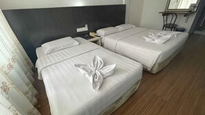 A hotel room with two beds, a nightstand, a mirror, and a wooden floor. - Hotel Hsiang Garden (Sandakan)