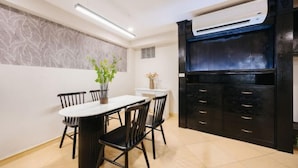 Una cocina moderna con un armario negro, una encimera blanca y un aire acondicionado instalado en el techo.