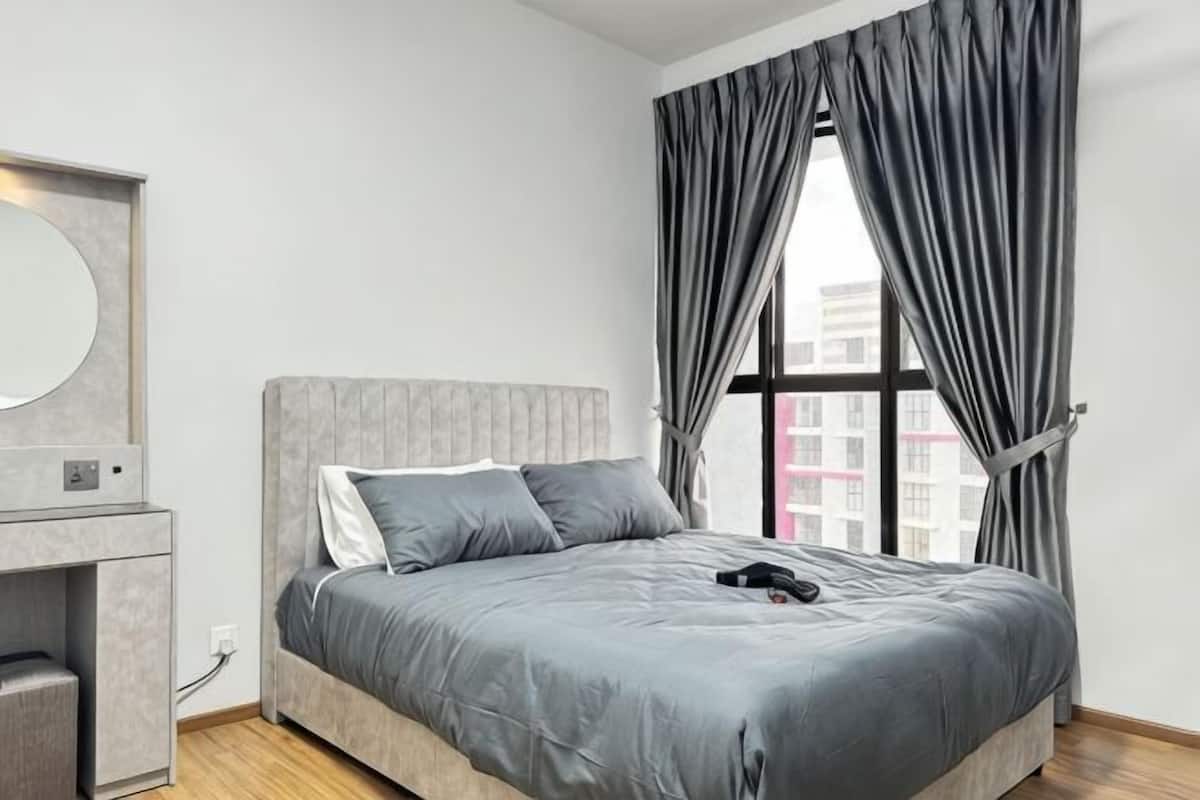 Ein Schlafzimmer mit einem Bett, einem Schminktisch, einem Spiegel und einem Fenster mit Vorhängen.