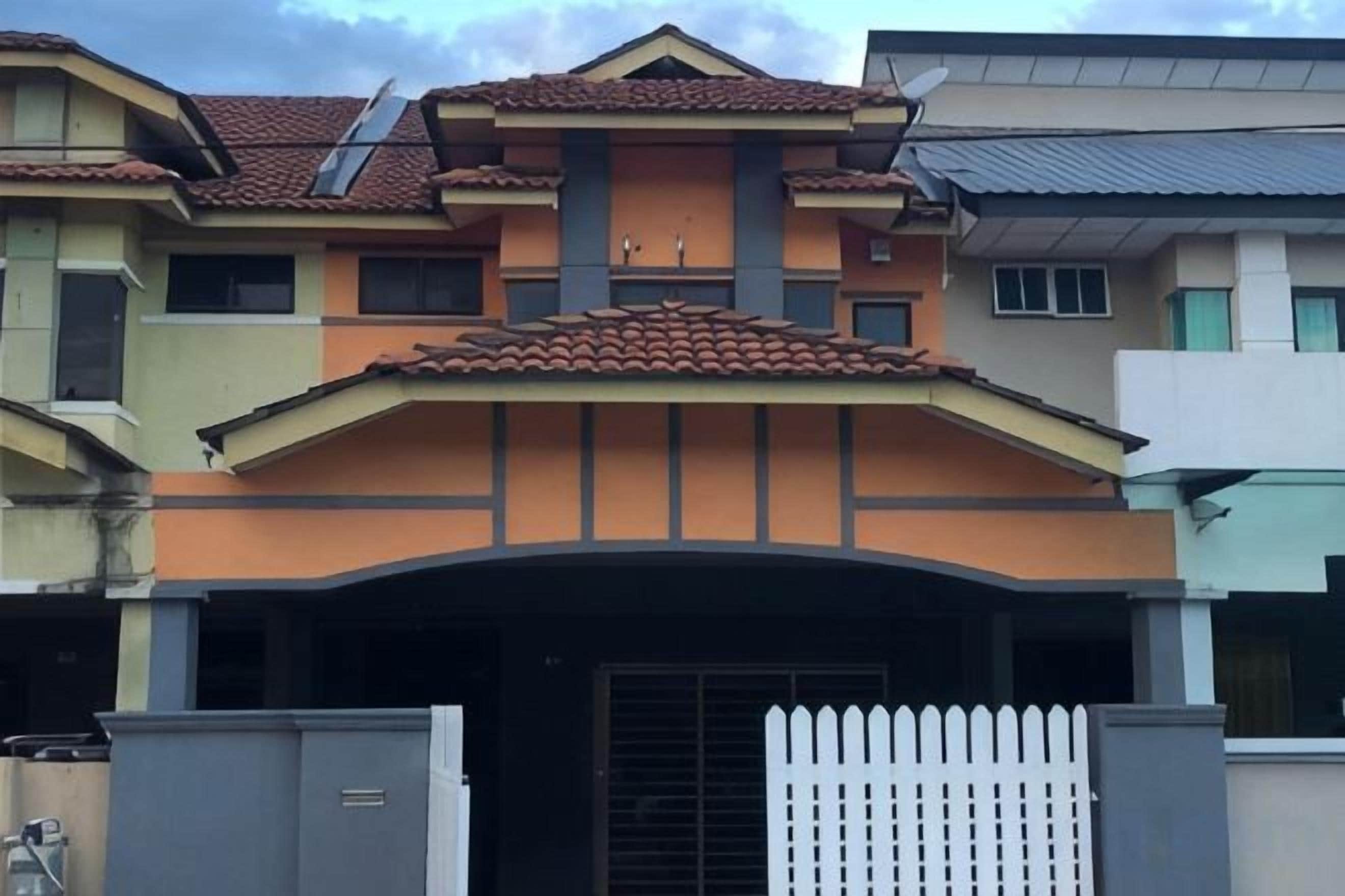 A multi-story residential building with a gated entrance, a flat roof, and a visible garage.