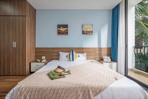 Een slaapkamer met een bed, nachtkastjes, een kledingkast en twee schilderijen aan de muur.