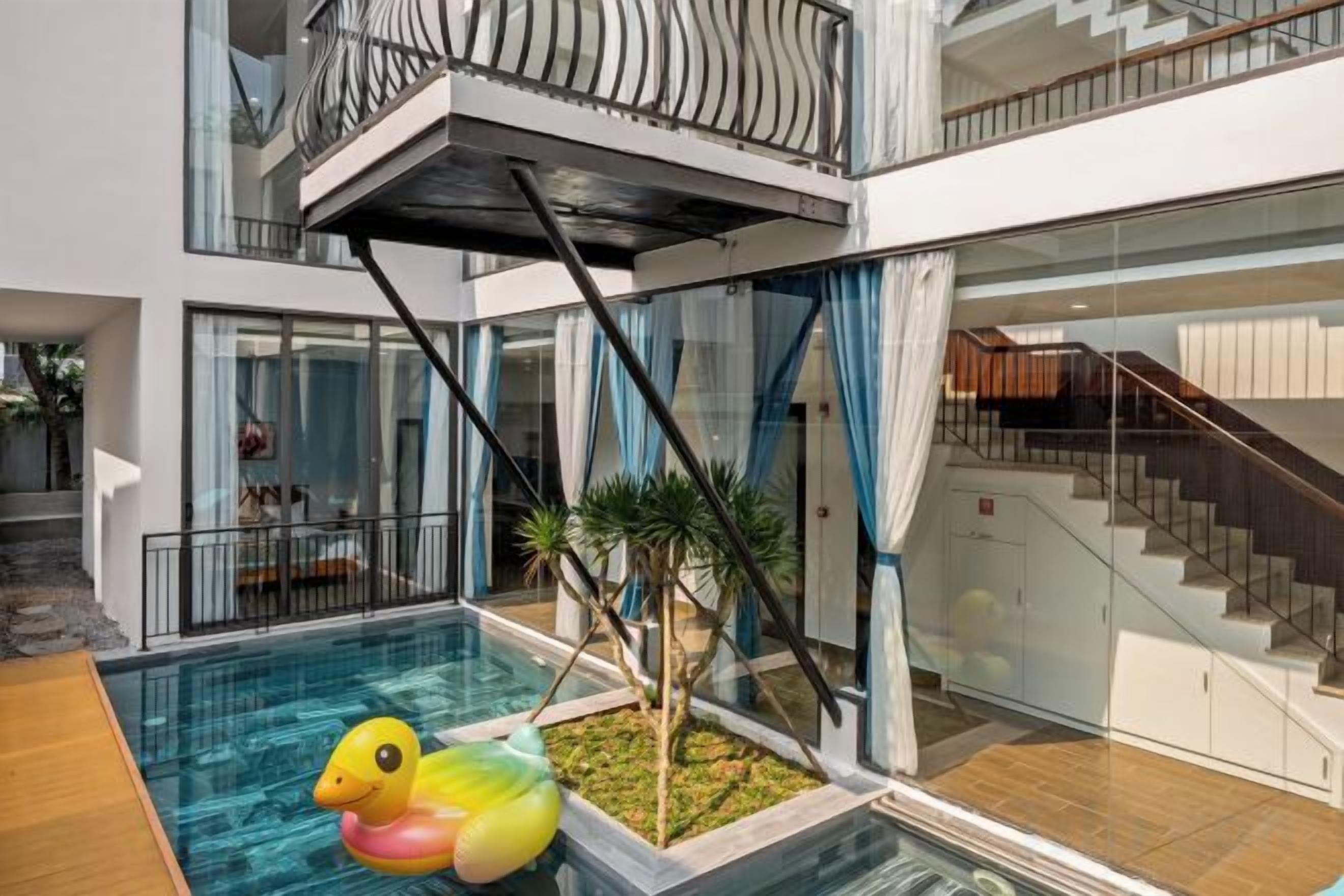 A modern building with a swimming pool, a staircase, and a balcony.
