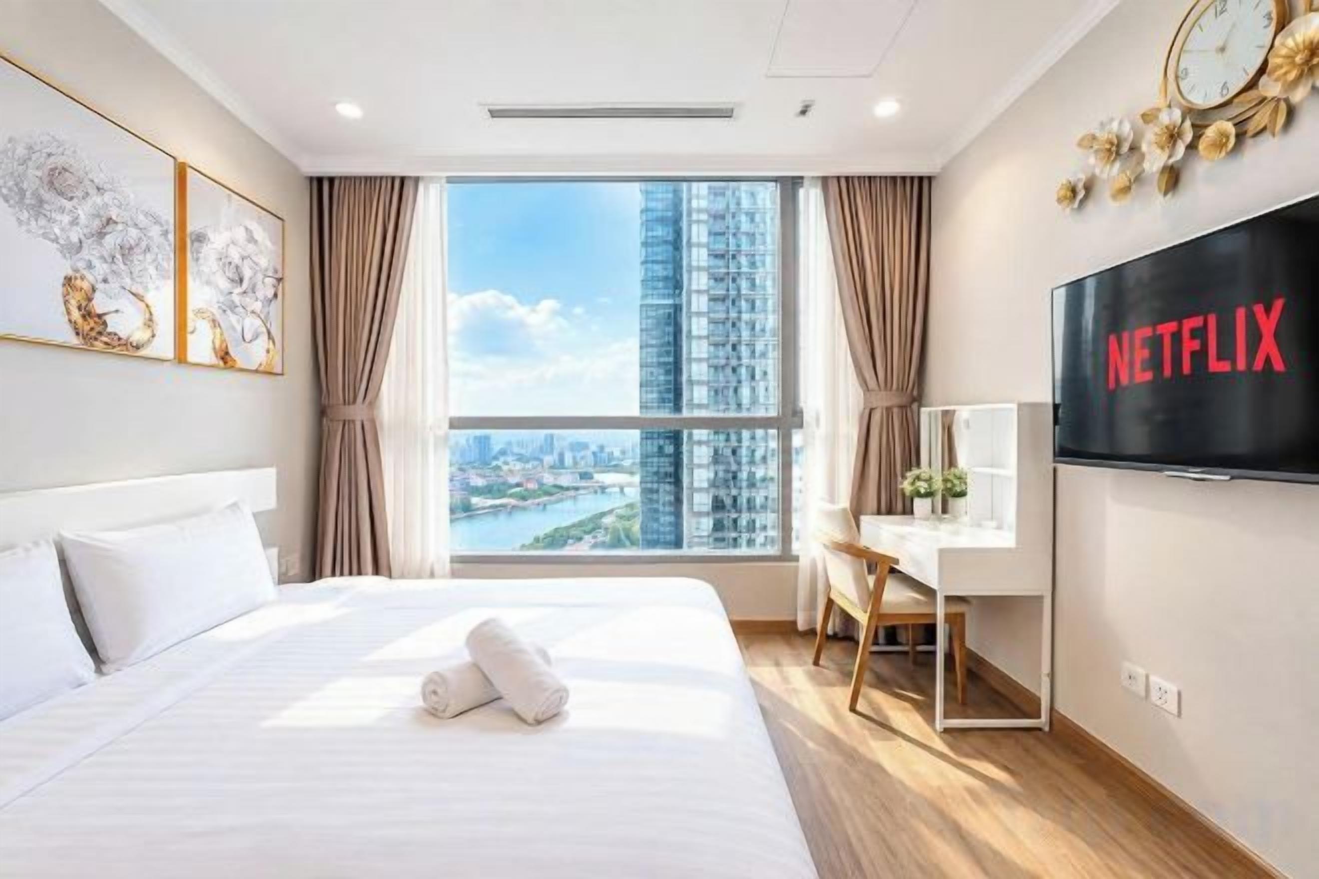 Une chambre d’hôtel avec un grand lit, un bureau, une télévision et une vue sur le paysage urbain.