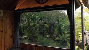 A room with a large window, wooden walls, and a clock on the ceiling. - The Village Resort in the Painting, Bao Loc (Bao Lam District)
