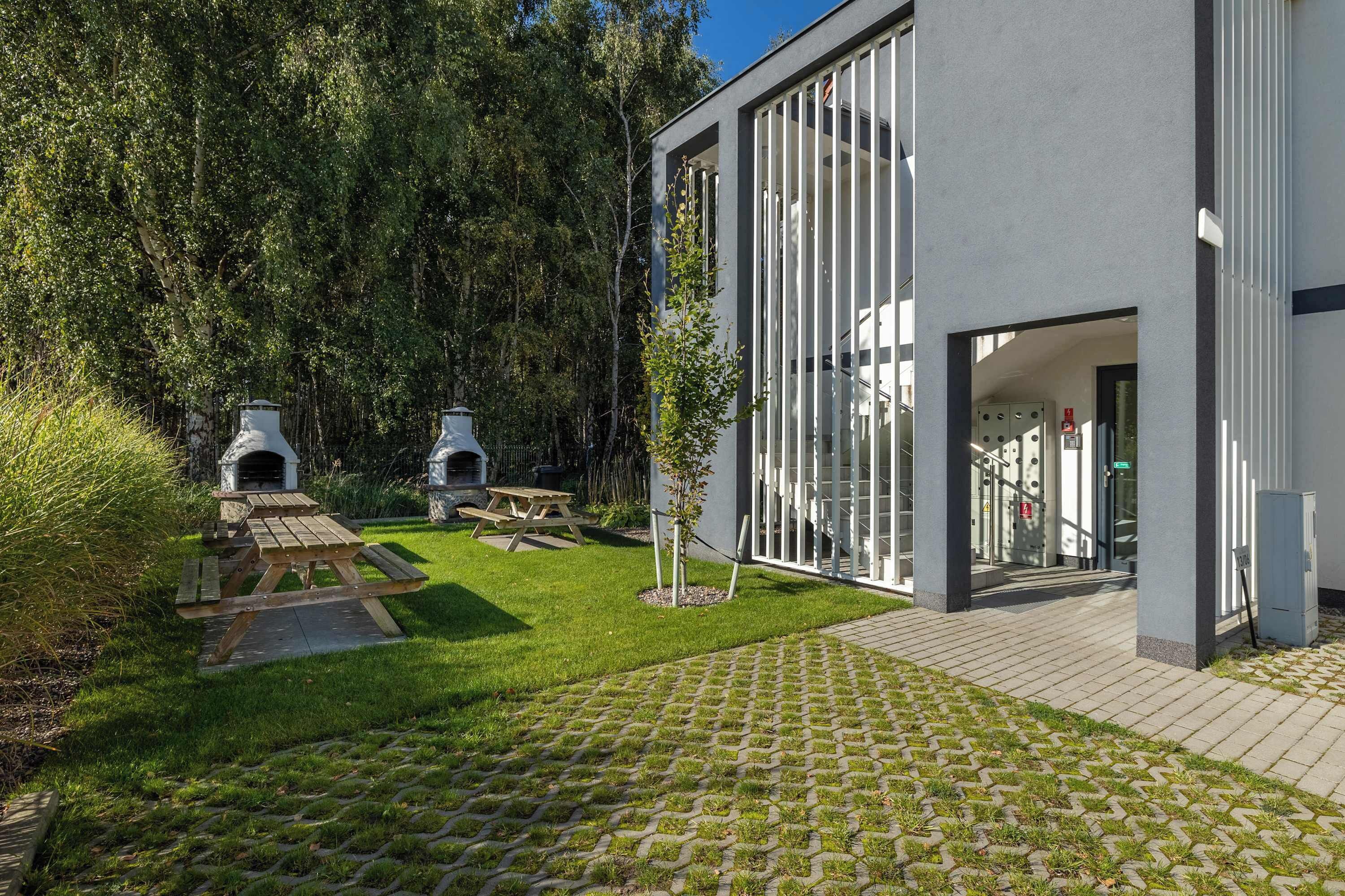 The exterior of the building surrounded by trees. Green lawns offer space for rest.