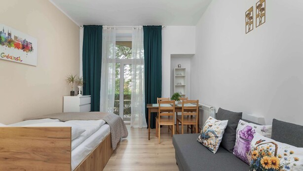 Una habitación moderna con una cama, un sofá, una mesa de comedor y una silla.